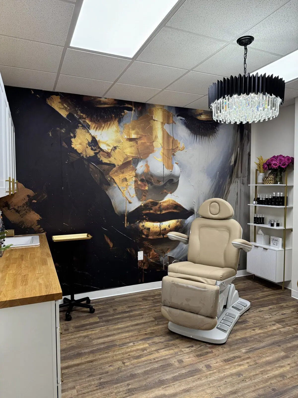 Opteluxe Wellness aesthetic treatment room with signature gold mural